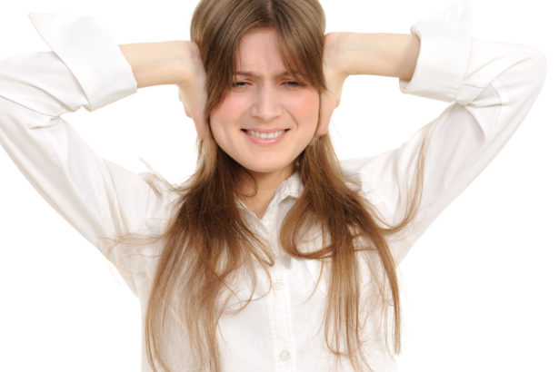 woman holding ears in frustration